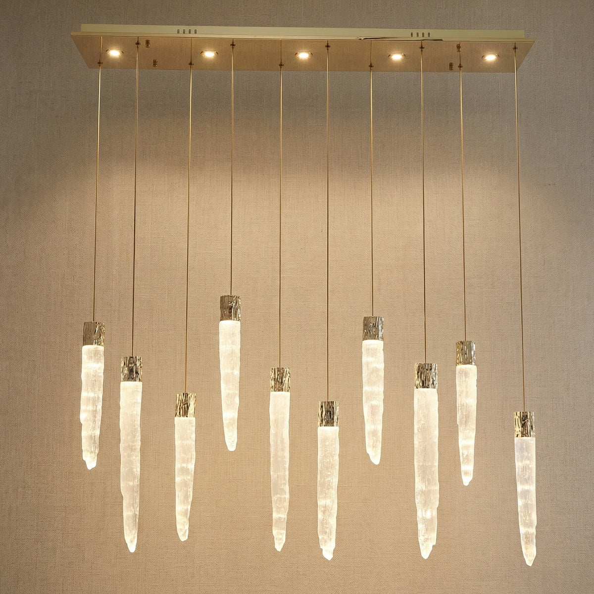 Modern dining room with K9 crystal icicle linear chandelier over long wooden table — Yiosi Halsey 47 inch