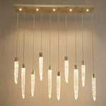 Modern dining room with K9 crystal icicle linear chandelier over long wooden table — Yiosi Halsey 47 inch